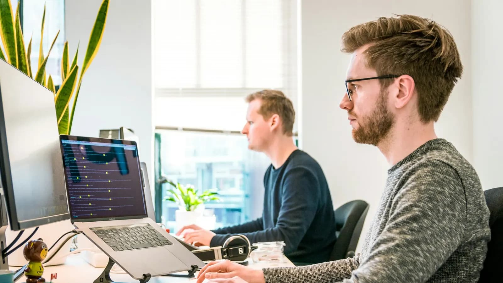 IT support engineers working through the helpdesk queue at their desks
